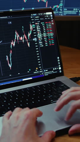 Man trader monitors market charts on laptop, screen and smartphone at home. Analyzing real-time trading data, considering investment strategies. Professional investor engaged in day trading, Evening