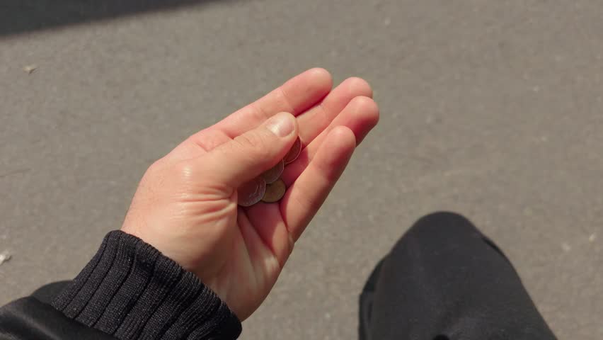 Hand counting British coins in natural sunlight from first person perspective. Personal finance, budgeting, small change money concept with UK currency held outdoors. Everyday expenses, savings