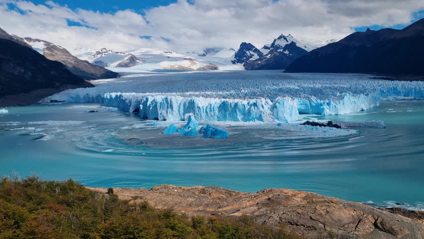 Waves ripple across Lago Argentino after a large chunk of ice breaks off the Perito Moreno Glacier, forming mesmerizing circular patterns on the water in a powerful display of natural movement