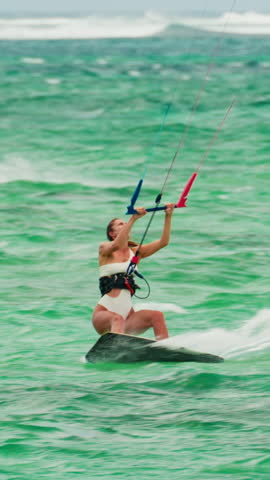  Sports woman kitesurfing in ocean in white bikini. Extreme summer sports