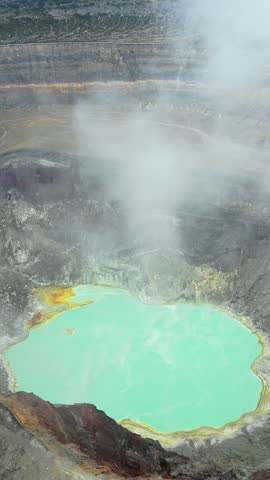 Stunning aerial video captures poas volcano crater with turquoise lake and steam rising.