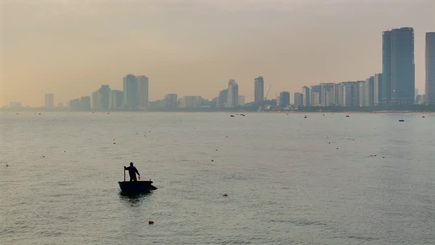 Vietnamese Fishermen in Traditional Thung chai Boat. The Sea near Da Nang city in Vietnam, Aerial Sunrise Drone Shot.