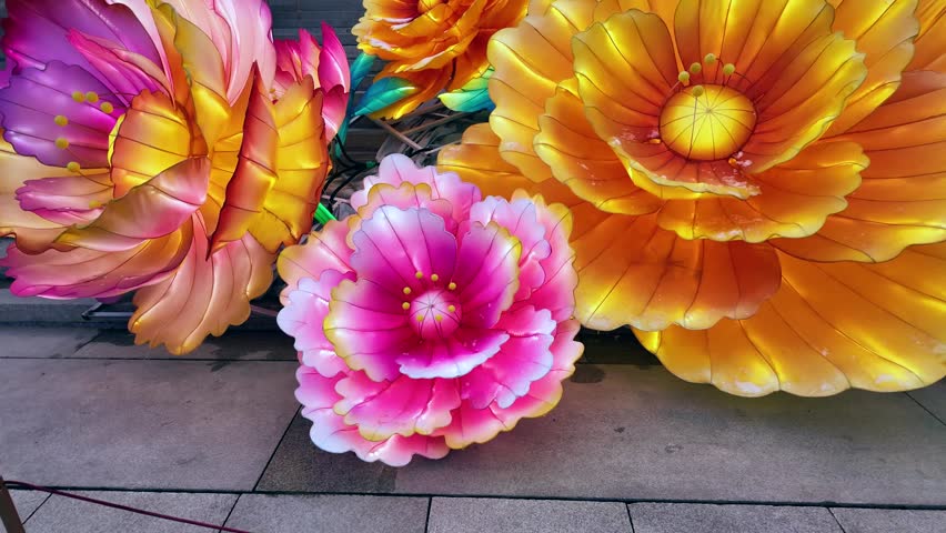 Grand traditional Chinese palace with wide staircase, vibrant floral decorations, and visitors in cultural attire creating festive historic atmosphere