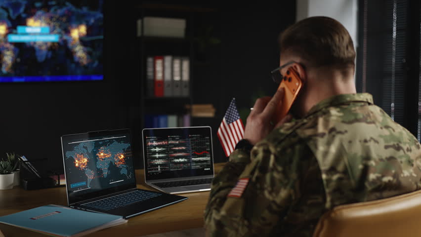 U.S. army general watching international armed conflicts while talking on phone