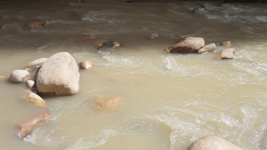 The running shallow river at Zion National Park, flowing over large rocks.