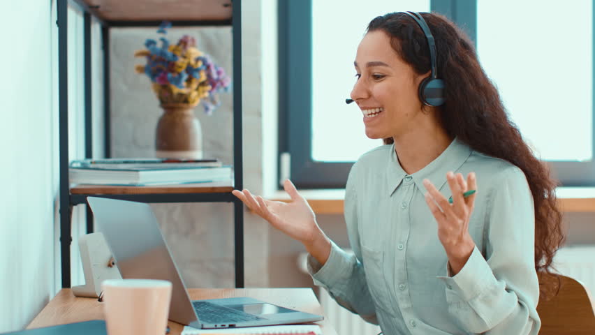 Woman With Curly Hair Engages in a Virtual Meeting at a Modern Workspace During the Day