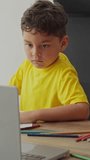 Boy using laptop at table with school materials during online class, indoor digital educational activity - Powered by Shutterstock - Get 15% off with code: PIKWIZARD15