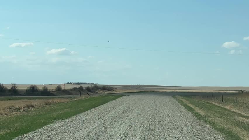 Scenic driver perspective along remote countryside gravel transportation route