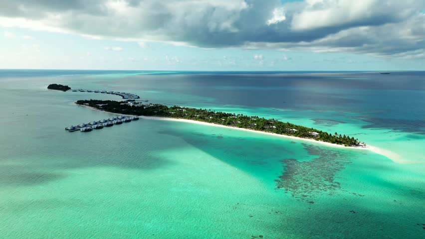 Maldives resort island with two bungalow piers white beach coral reef and turquoise ocean