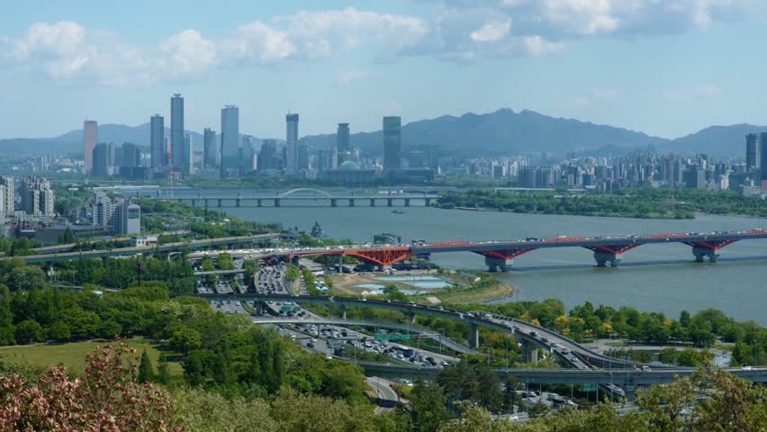 Seoul Skyline View with Red Bridge and Highway Traffic
