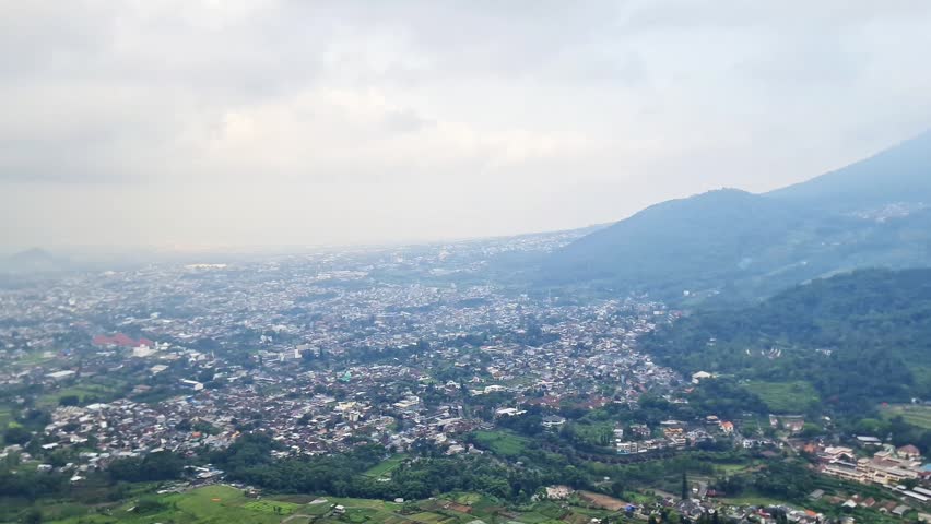 Highland Summit Panorama with Villages, City Valley, and Rolling Hills Beneath Cloudy Sky
