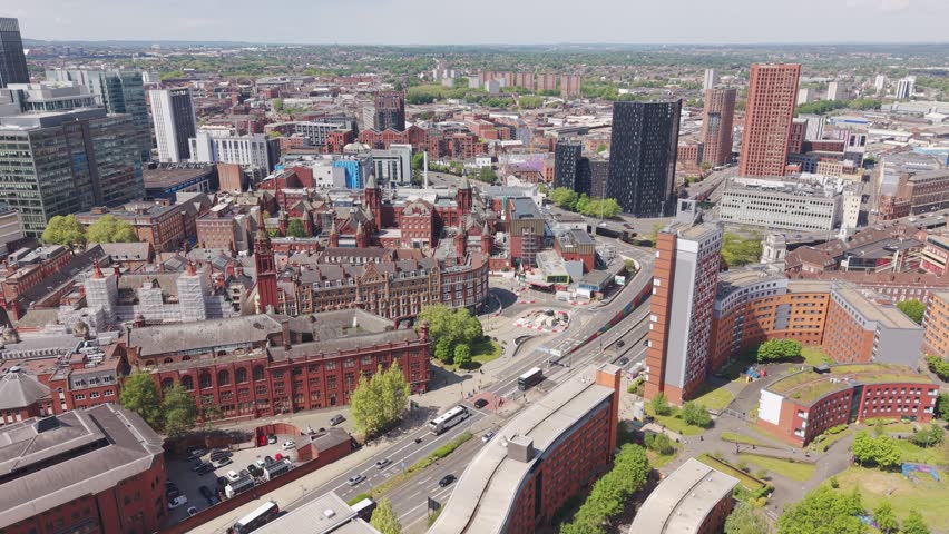 Cinematic drone flyover capturing busy roads, flowing traffic and striking modern and historic architecture in Birmingham city centre, England.
