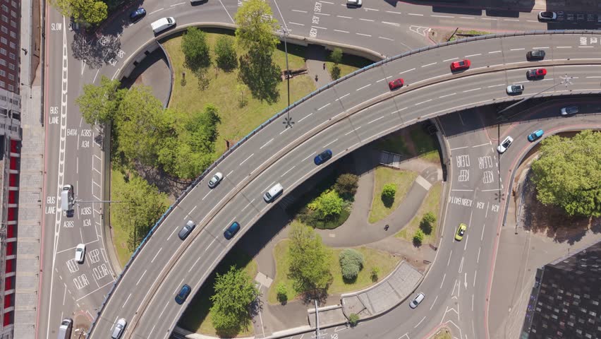 Cinematic drone flyover capturing busy roads, flowing traffic and striking modern and historic architecture in Birmingham city centre, England.