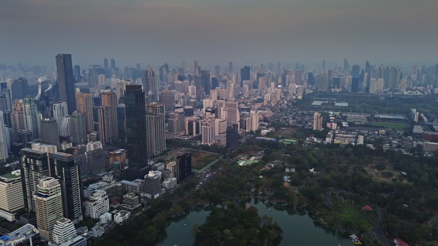 Aerial view of Bangkok city skyline in dusk after sunset. Urban skyscrapers and office buildings in business district, Thailand, 4k