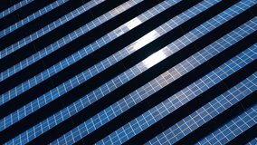 High angle view of solar array with bright sunlight. Photovoltaic modules in rows with strong sun reflection on a dark background, aerial industrial energy concept. - Powered by Shutterstock - Get 15% off with code: PIKWIZARD15