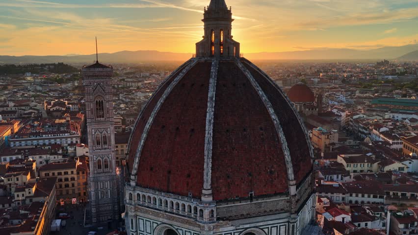 flying around Florence cathedral dome at sunset, scenic drone shot of Santa Maria del Fiore cathedral with the setting sun, travel in Italy