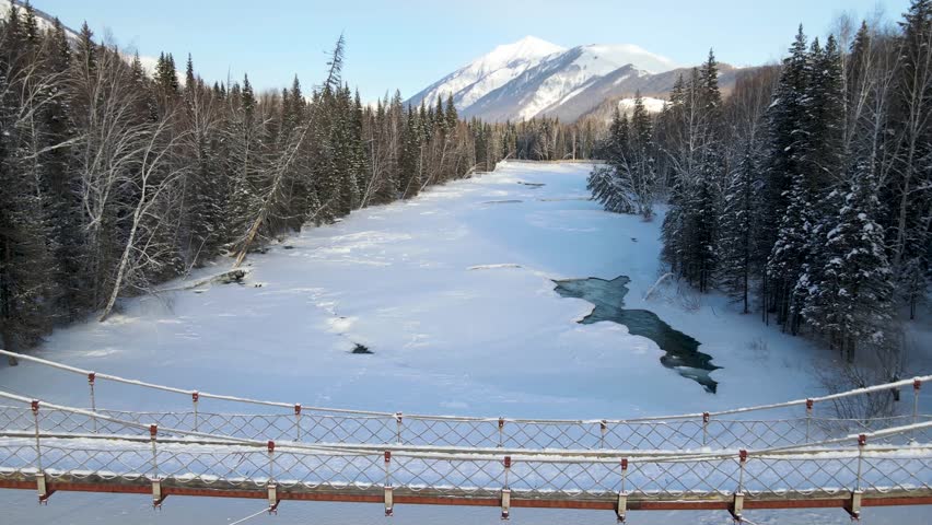 Winter landscape with a frozen river and snowcovered mountains