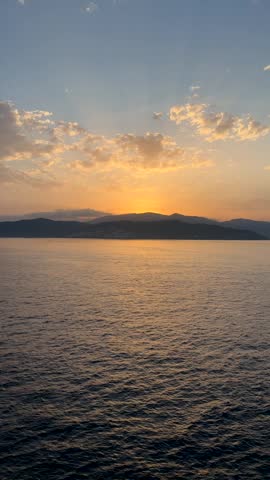 Sunset over sea with distant southern Spain coastline and mountain silhouette