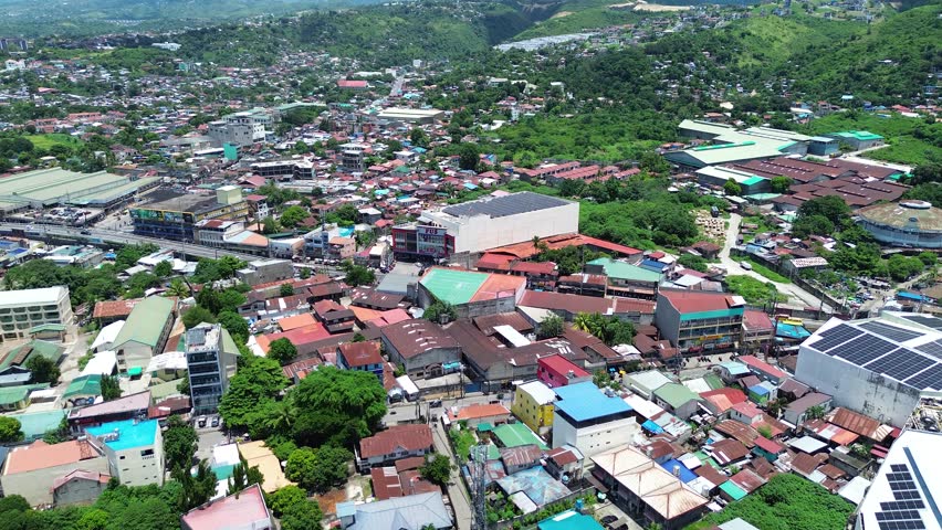 Drone aerial footage of urban residential neighborhoods and city buildings in Talisay, Cebu, Philippines.