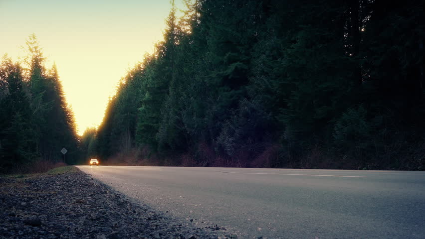 Car Passes On Rural Highway In Sun Glow