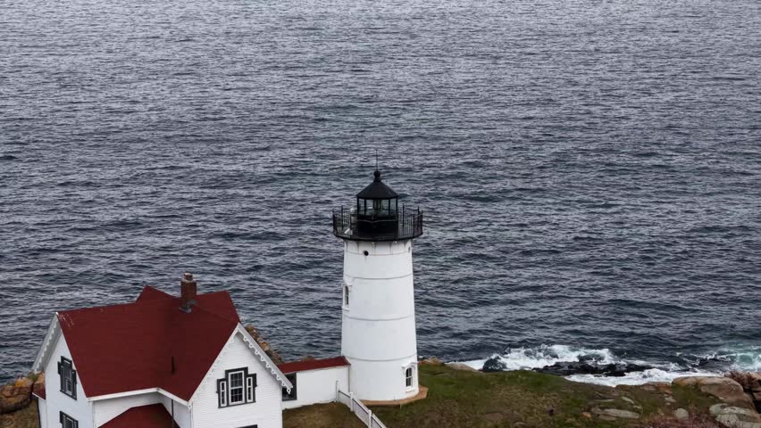 A stunning aerial view of a lighthouse on a rocky coast.