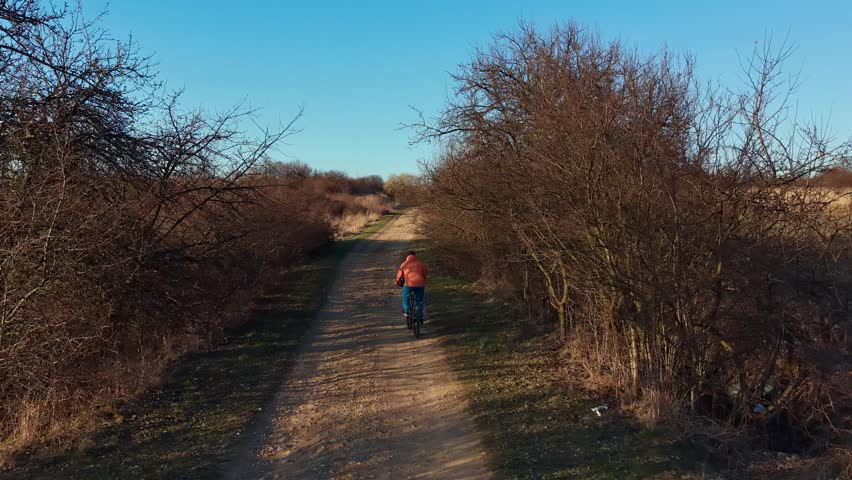 One person cycling on a rural track