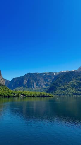 Tranquil lake view under clear blue skies in a vertical shot.