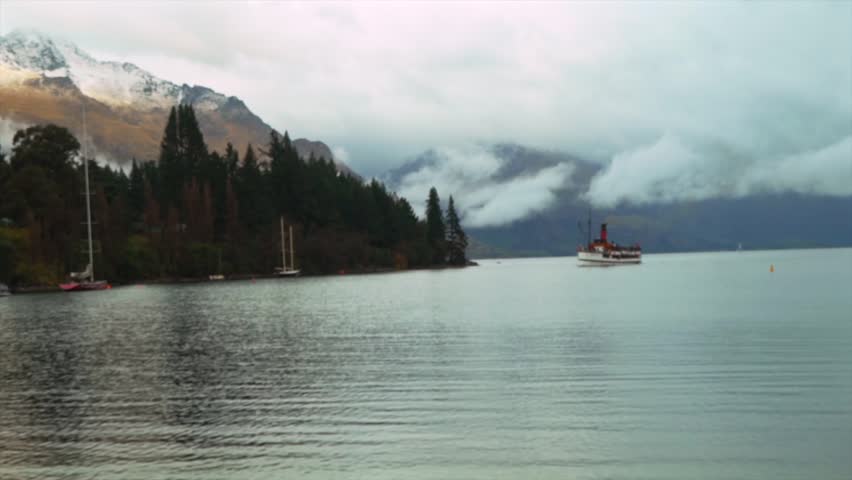 Cruise tour boat sailboat Winter Queenstown Bay Beach sunrise sunset Lake Wakatipu Queenstown Gardens New Zealand South Island Glenorchy landscape snow covered peaks morning cloudy fog rainy zoom out