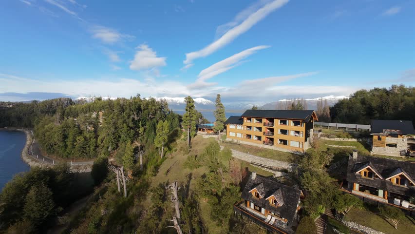 Río Correntoso in Villa La Angostura Neuquén Patagonia Argentina with lakeside lodges, forested slope and Lake Nahuel Huapi nearby captured in fast FPV acro drone flight dynamic forward motion