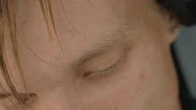 Closeup caucasian man eyes with headphones. Green irises and freckles, hair strands falling over brow, shifting sideways glances conveying curiosity and focused thought, subtle lighting and intimate - Powered by Shutterstock - Get 15% off with code: PIKWIZARD15