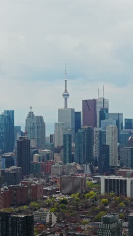 Urban Toronto skyline featuring CN Tower and financial district with tall modern skyscrapers and residential buildings during daytime in vertical