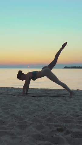 Stretching outdoors. yoga silhouette. yoga beach. Athletic young woman is practicing yoga at the beach during sunset or sunrise. Fitness training outdoors. doing sports in the morning.