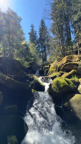 Clear mountain water flowing rapidly over rocks in a natural forest landscape with detailed textures, movement, and fresh outdoor atmosphere.