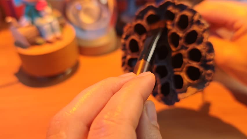 ASMR Brushing Dry Dried Lotus Pod With Makeup Brush, Warm Orange Soft Lighting. Close-up ASMR video: gentle hand brushing the textured surface of a dried empty lotus seed pod with a soft makeup brush. Cozy warm orange ambient glow, small whimsical toy decor blurred in the soft background. Ultra soothing, quiet scratching and brushing trigger sounds designed for deep relaxation, tingles, stress relief, sleep aid and calm background ambiance. No talking, 