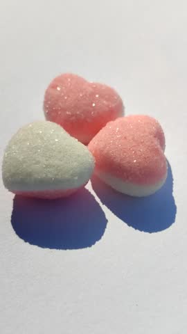 Pink and white heart shaped candy with sweet colorful design, perfect for romantic and festive themes.
