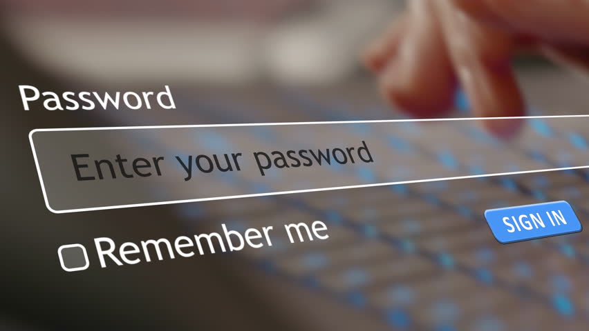 User types a password into a website form box on a browser. In the background, a hacker watches over a computer screen to gather personal details.