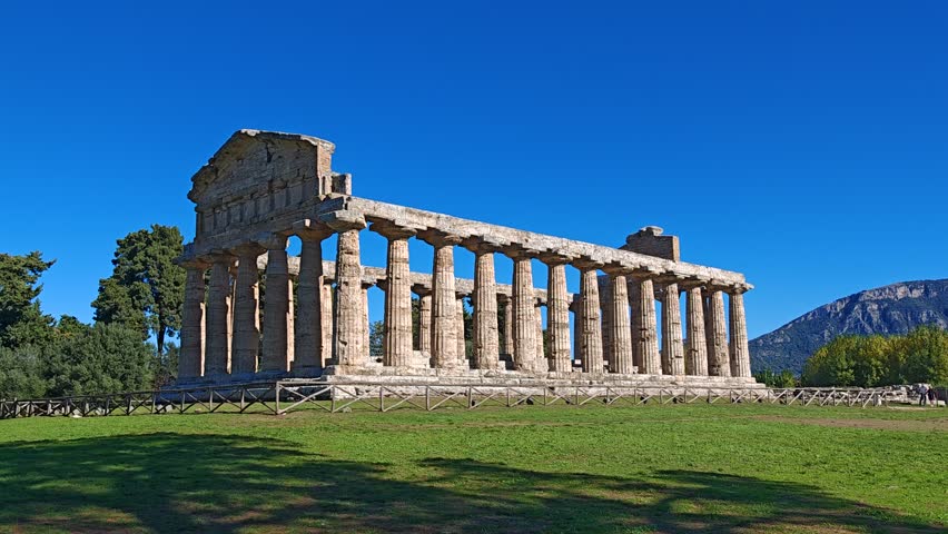Ancient Greek Temple of Athena in Paestum, Italy at sunny day with blue sky. Famous archaeological site of Paestum, Magna Graecia, ancient ruins.