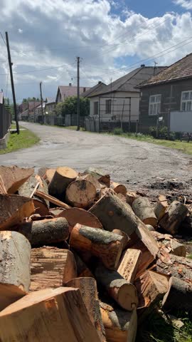 man hauling chopped firewood into rural property
