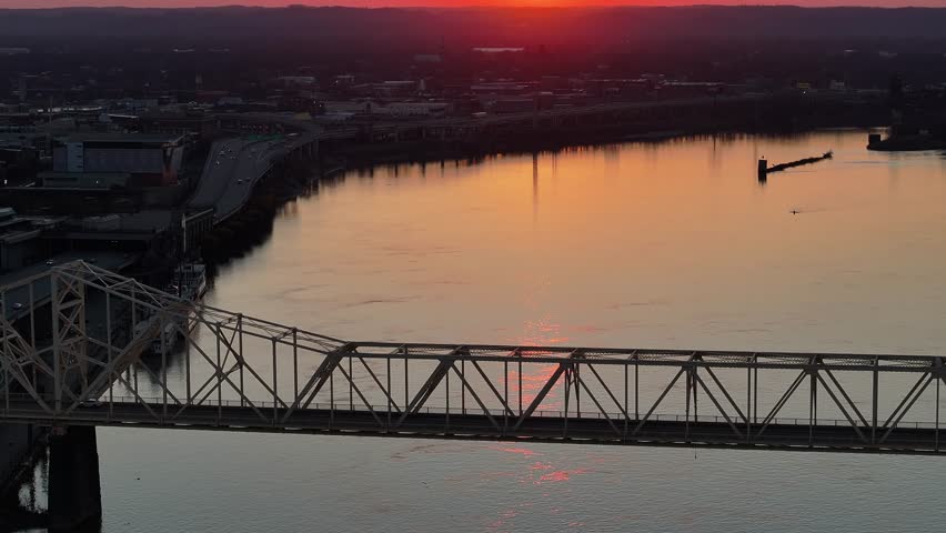 Aerial view of the George Rogers Clark Bridge over the Ohio River at sunset with the city skyline in the background Louisville, Kentucky, United States.