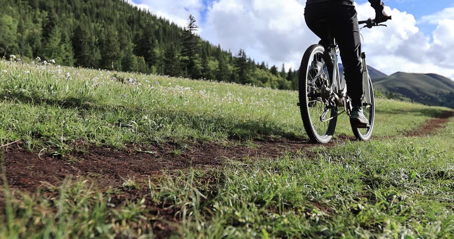 Riding mountain bike on the forest and grassland trail