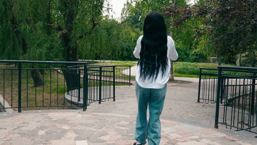 Walking through a park with trees and paths in the background on a cloudy day