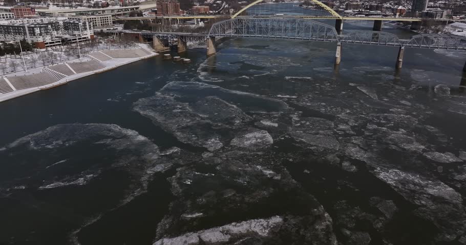 Aerial view of large ice floes floating on the Ohio River near bridges and snow-covered banks in Cincinnati, Ohio, United States.