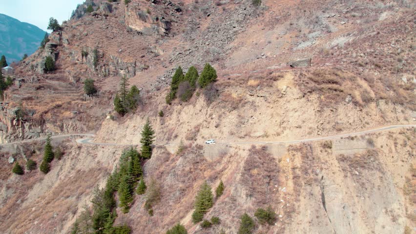 Car Driving on Dangerous Mountain Edge Road – Dramatic Cliffside Highway Aerial View