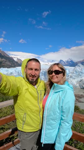 Middle-aged man and woman taking a selfie with the Perito Moreno glacier in Los Glaciares National Park, Santa Cruz, Patagonia, Argentina.