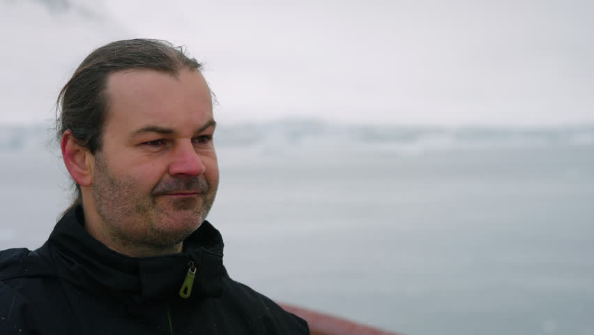 Portrait Of A Man Taking Videos Of Frozen Landscape During An Expedition In Antarctica. Close-up Shot