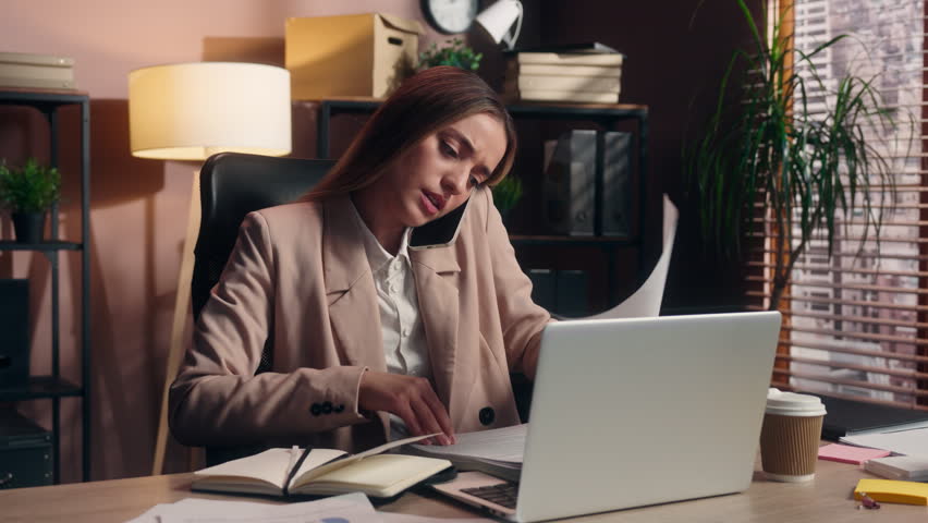 Dissatisfied Caucasian business woman leader with papers searching contract talking mobile phone female girl businesswoman project founder talk stressed search file stats documents throwing in office