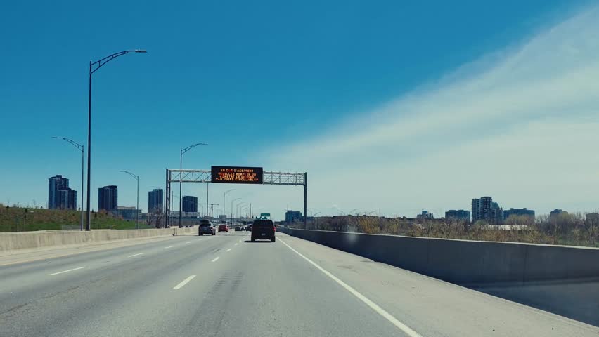 POV driving footage along a highway in Montreal, Quebec, Canada on a sunny day.
Smooth forward motion showcasing urban infrastructure, road lanes, and surrounding city environment.
Ideal for travel, transportation, commuting, and background driving visuals.