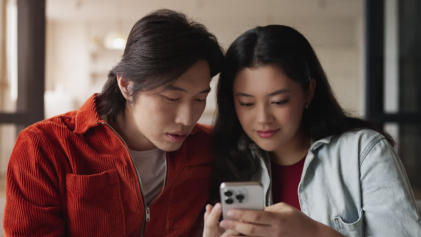 Korean couple amazed while scrolling phone after getting many likes and views