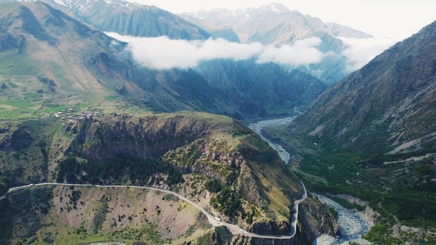 Aerial view of a mountain valley with a winding road