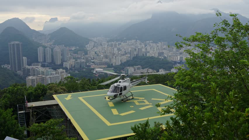 Helicopter take off from helipad on Sugarloaf, Rio de Janeiro, Brazil, with urban panorama